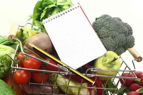 Shopping list with pencil, basket and fresh vegetables — Stock Photo, Image