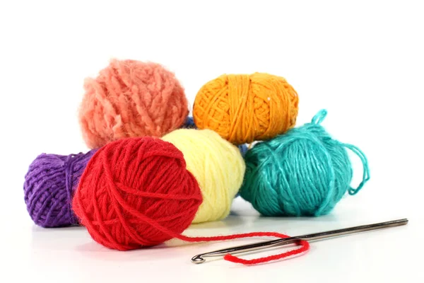 Bolas coloridas de lã com gancho de crochê em um fundo branco — Fotografia de Stock