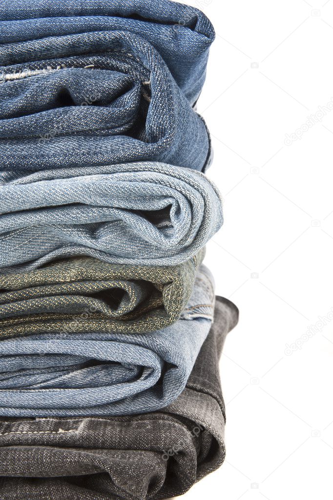 Lot of blue jeans isolated on white