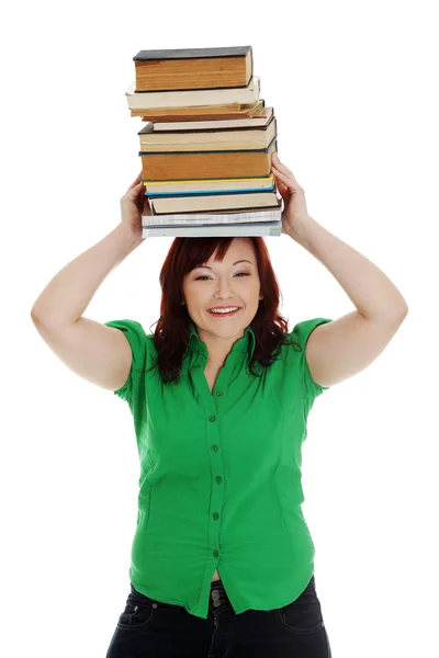 Ung kvinna (student) med böcker på hennes huvud — Stockfoto