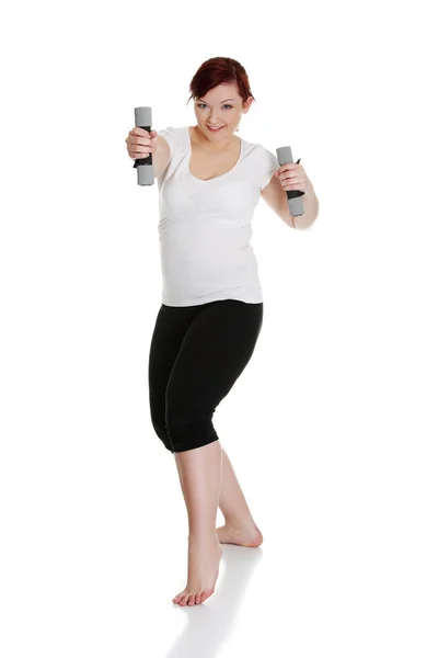 Mulher jovem durante o tempo de fitness e exercício com halteres — Fotografia de Stock