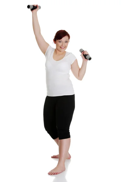 Mujer joven durante el tiempo de fitness y hacer ejercicio con pesas —  Fotos de Stock
