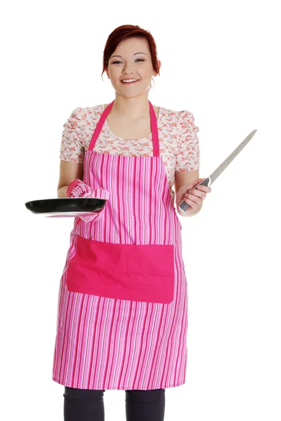 Gelukkig vrouw in roze keuken schort. — Stockfoto
