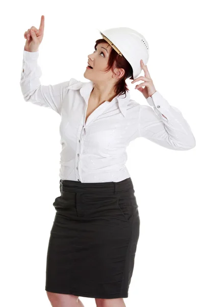 Affärskvinna i vit hjälm pekar uppåt. — Stockfoto