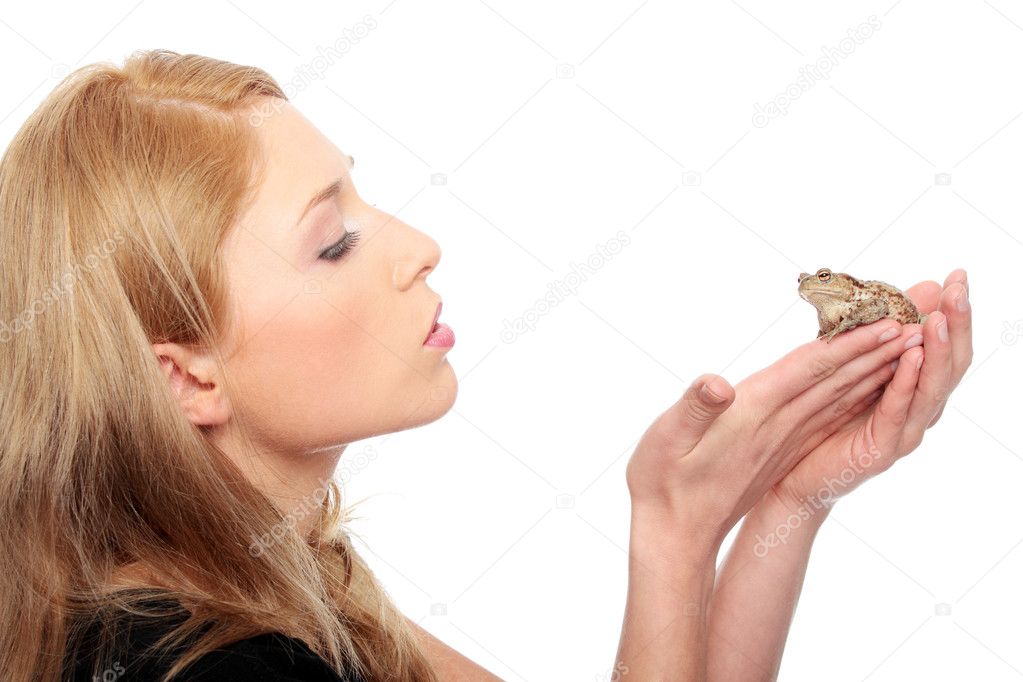 A gorgeous young blond woman kissing a frog