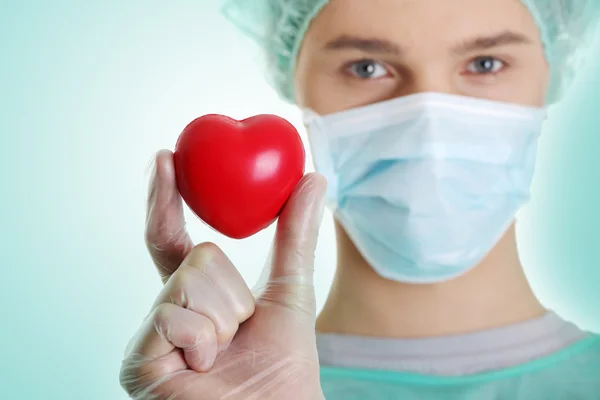 Médico segurando brinquedo em forma de coração — Fotografia de Stock