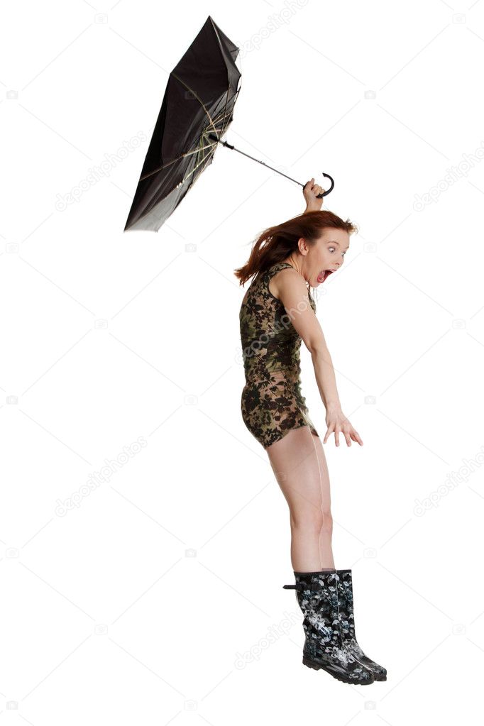 Young woman with umbrella blown by wind.