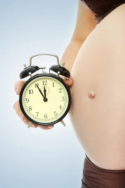 알람 시계와 함께 임신한 여자 — 스톡 사진