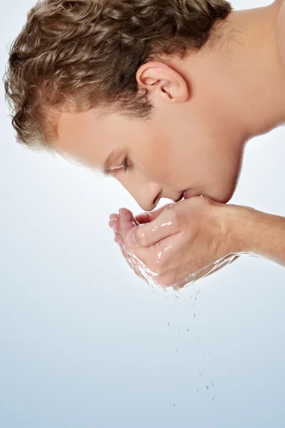 Ung man tvättar ansiktet — Stockfoto