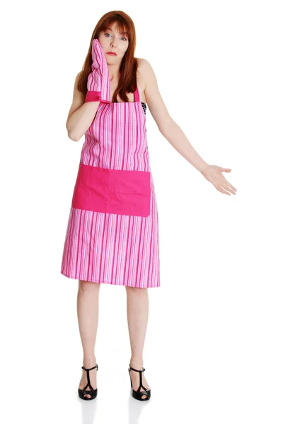 Junge unruhige Hausfrau in rosa Schürze — Stockfoto