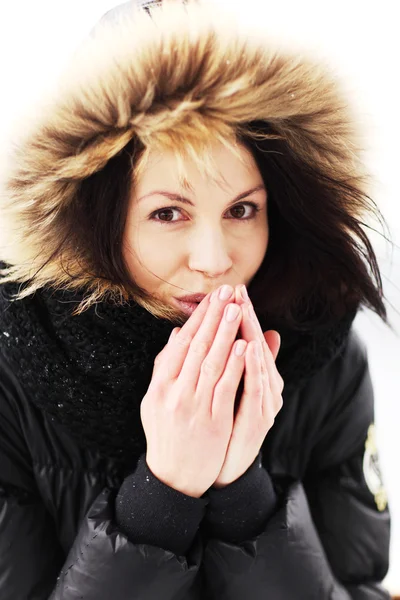 Woman trying to warm her hands with a breath — Stockfoto