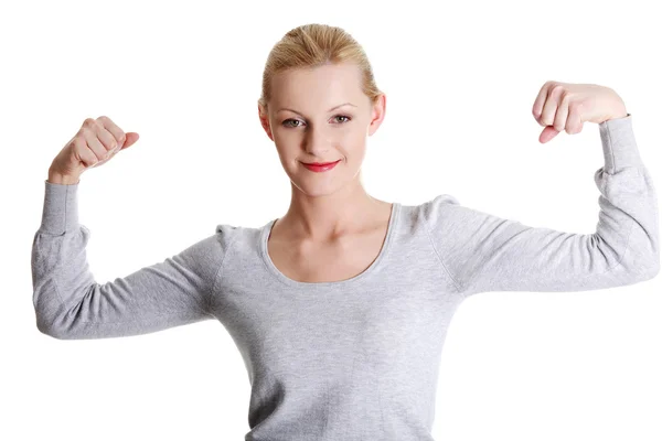 Leuke jonge lachende vrouw toont haar biceps — Stockfoto