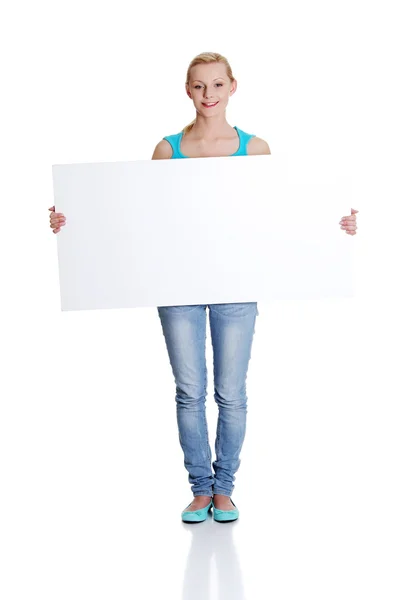 Belle jeune femme tient blanc panneau de tableau blanc — Photo