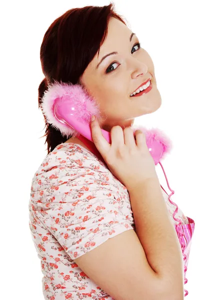 Szczęśliwa kobieta w różowym fartuchu mówi przez telefon. — Zdjęcie stockowe