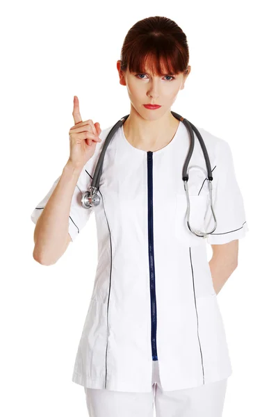 Kvinnliga läkare hotar eller pekar uppåt — Stockfoto