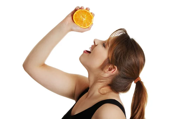 Mulher apertando laranja fresca — Fotografia de Stock