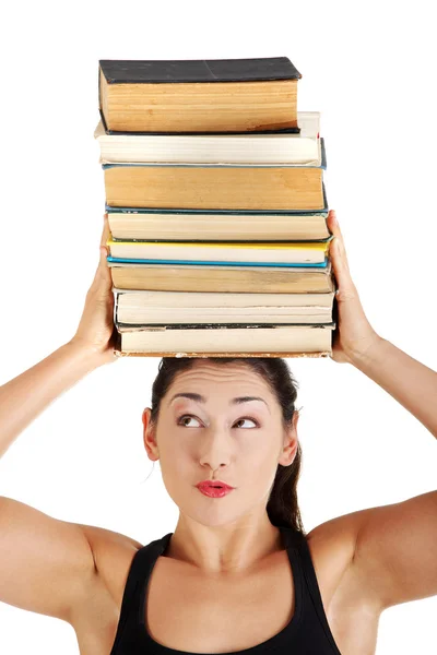 Jeune femme (étudiante) avec des livres sur la tête — Photo