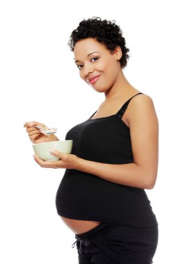 Pregnant woman eating healthy food. clipart