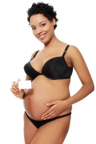 Zwangere vrouw gekleed in zwarte lingerie. — Stockfoto