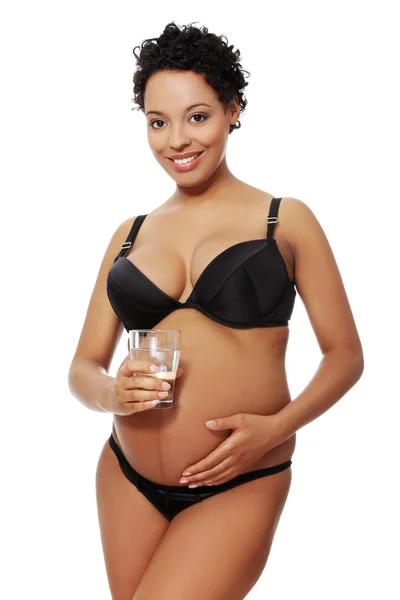 Blij zwangere vrouw gekleed in zwarte lingerie. — Stockfoto