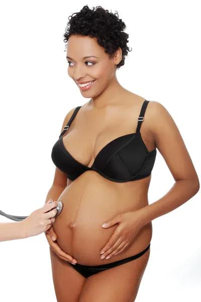 Blij zwangere vrouw gekleed in zwarte lingerie. — Stockfoto