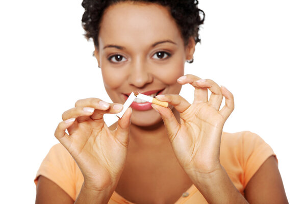 Беременная женщина ломает сигарету
.