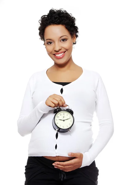 目覚まし時計と妊娠中の女性. — ストック写真