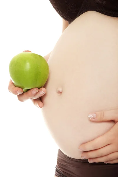 Vientre de una mujer embarazada con manzana verde — Foto de Stock