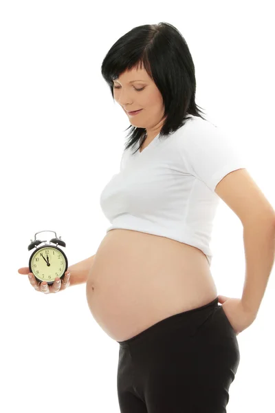Mulher grávida segurando despertador — Fotografia de Stock