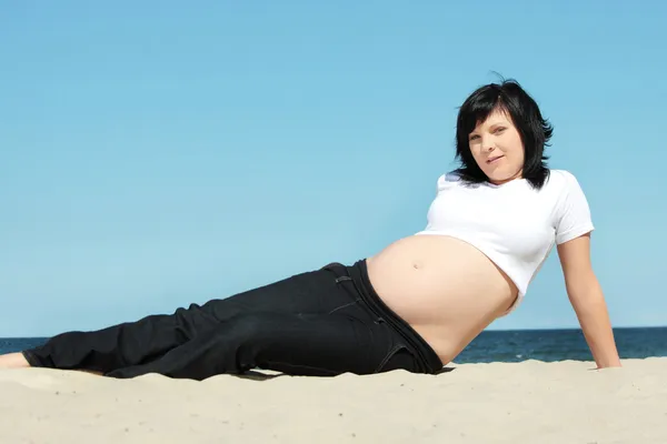 Mujer embarazada relajándose en la playa —  Fotos de Stock