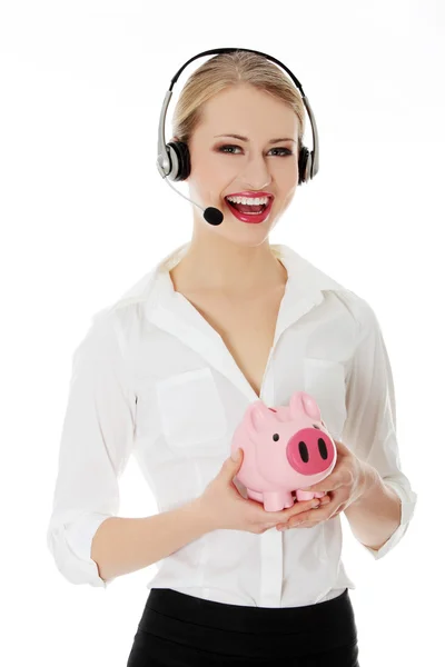 Piggy bank holding fejhallgatóval fiatal üzletasszony — Stock Fotó