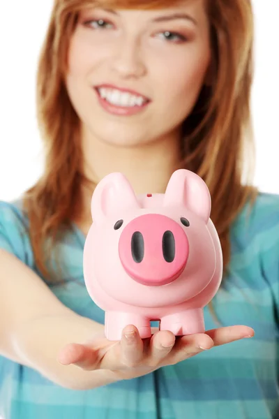 Jonge tiener vrouw toont haar roze piggy bank — Stockfoto