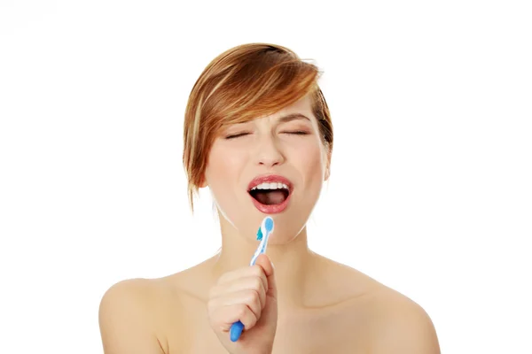 Красивая молодая женщина поет зубной щетке — стоковое фото