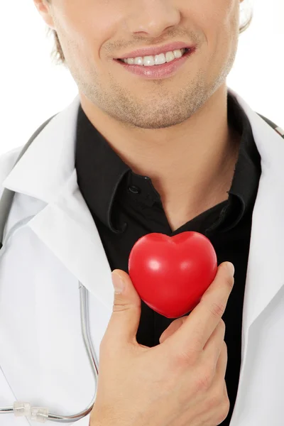 Доктор держит игрушку в форме сердца — стоковое фото
