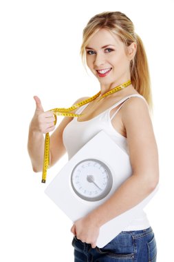 Woman with bathroom scale and measuring tape clipart