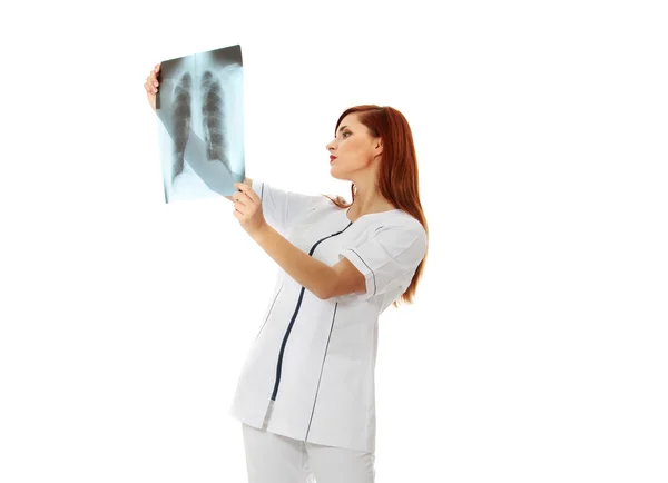 Досить біла жінка-лікар дивиться на рентгенівський знімок — стокове фото