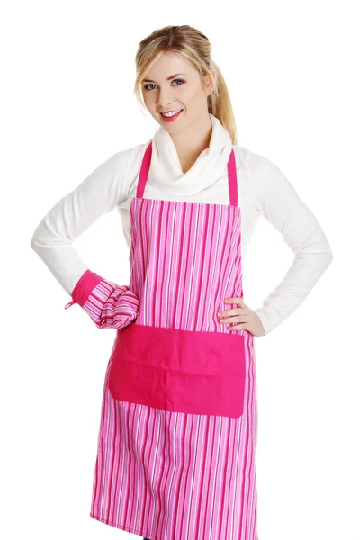 Молодая домохозяйка в розовом фартуке — стоковое фото