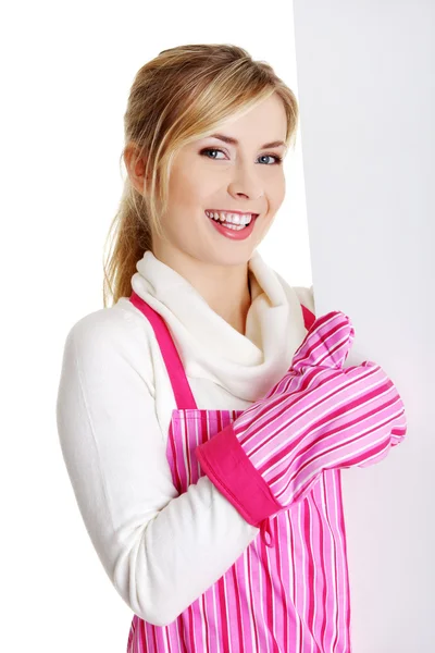 Szczęśliwa kobieta w różowy appron gospodarstwa znak billboard. — Zdjęcie stockowe