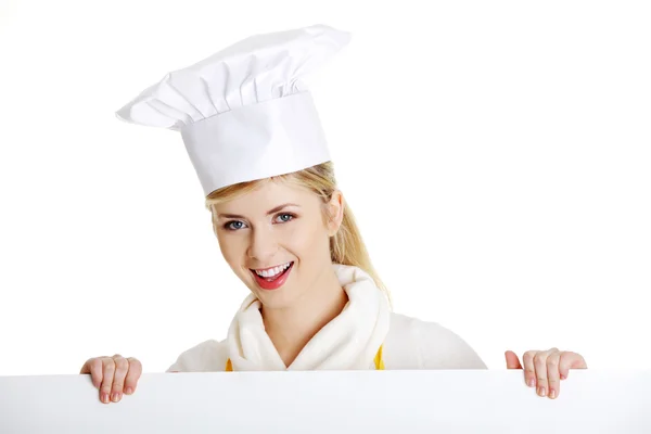 快乐的女人厨师或贝克看着纸标志广告牌. — 图库照片