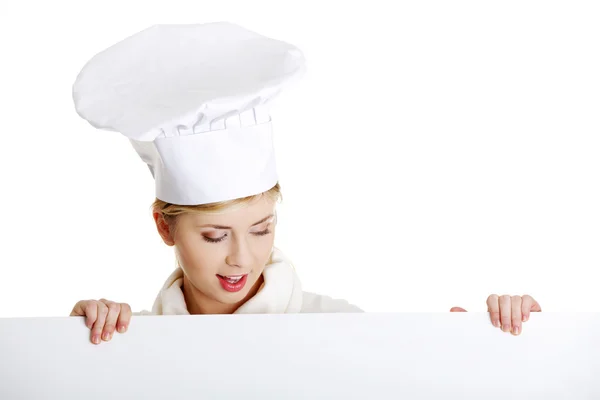 Glückliche Köchin oder Bäckerin, die über Pappschilder blickt. — Stockfoto