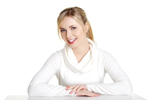 Young woman in casual clothes sitting at the desk — Stock Photo, Image