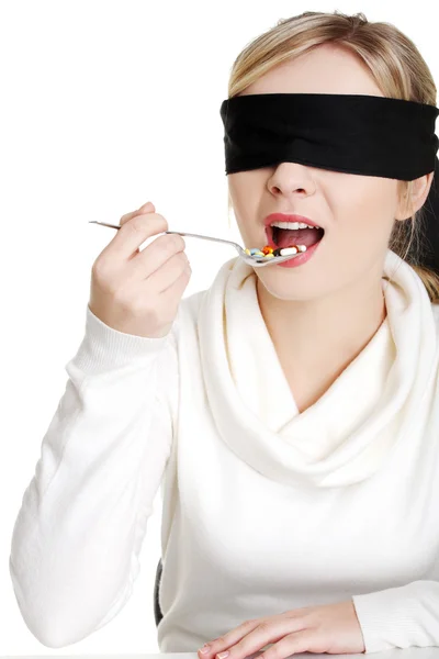 Vrouw met lepel met stapel van pillen blinddoek — Stockfoto