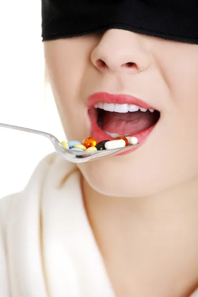 Blindfold woman holding spoon with pile of pills — Stock Photo, Image