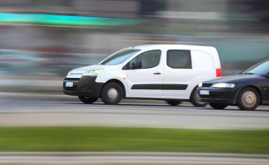 White minivan on road in traffic jam clipart