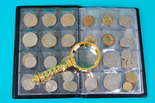 Magnifying glass and album with a collection of coins — Stock Photo, Image