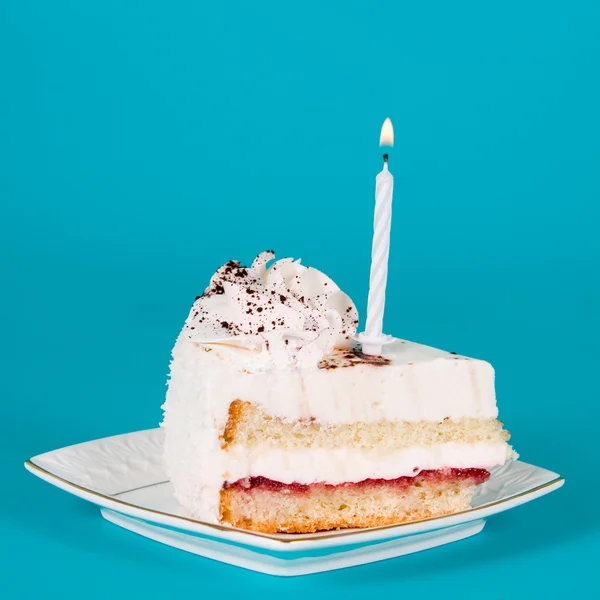 Piece of birthday cake with a candle — Stock Photo, Image