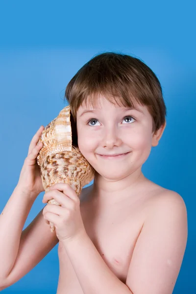 Jongen luistert naar shell — Stockfoto