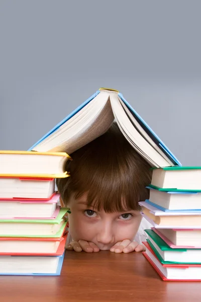 Junge versteckt sich hinter Büchern — Stockfoto
