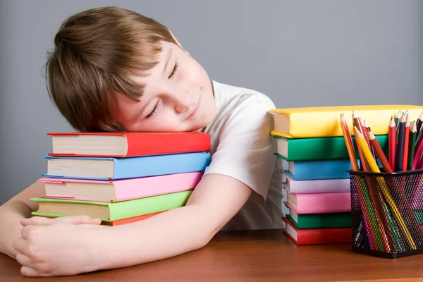 Trött pojke sover på böcker — Stockfoto