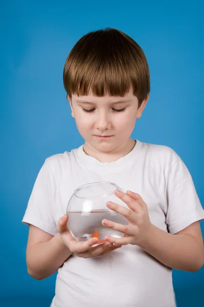 Boy holds a fishbowl with a goldfish — 图库照片